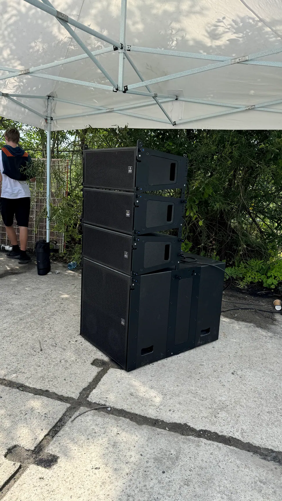 Stohovaná zostava line array reproduktorov a subwooferu pod prístreškom
