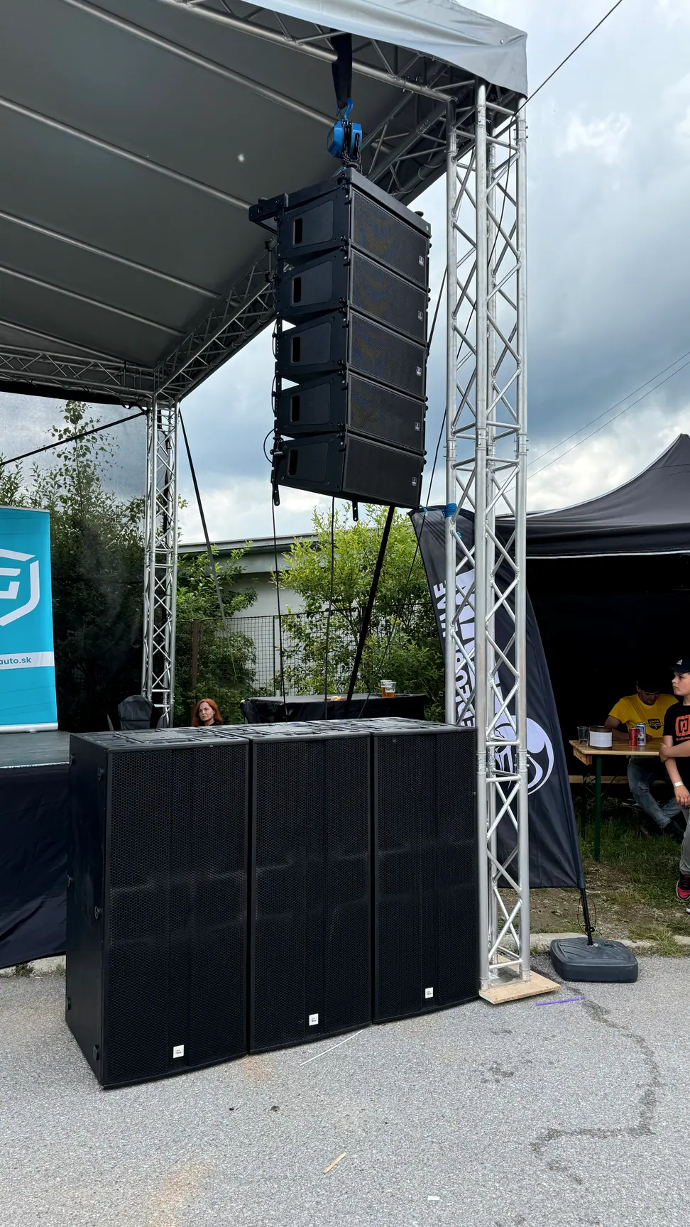 Zavesený line array a stohované subwoofery pri vonkajšom pódiu