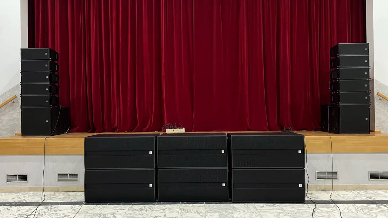 Ozvučenie kultúrnej sály: line array po stranách javiska a subwoofery pred pódiom